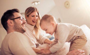 Mutlu sevgi dolu aile. Anne, baba ve oğul oynama ve evde sarılma.