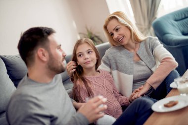 Üç sabahları kahvaltı onların ev oturma odasında birlikte olan aile.