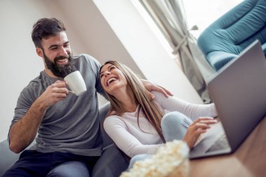 Having oyunculuk birlikte evde bir kanepede oturan genç mutlu çift.
