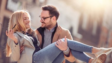 Mutlu genç çift dışarıda eğleniyor ve gülümsüyor..