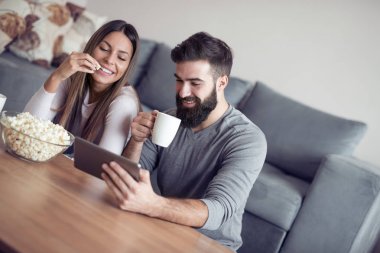 Romantik Çift tablet kullanma. Genç çift evde beraber sörf.