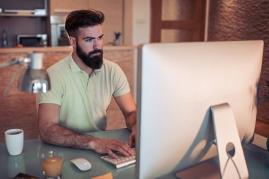 Genel müdürlükte dizüstü kullanarak yakışıklı genç erkek portresi.