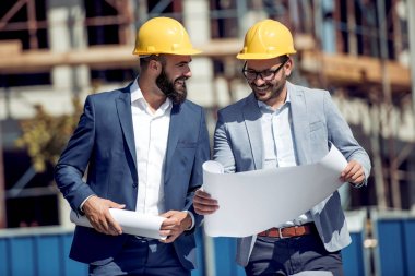 İki genç mimar ya da mühendis bir proje planını tartışıyor.