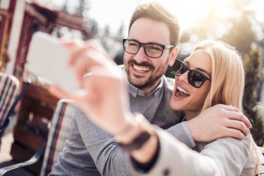 Mutlu genç çift alarak selfie Caddesi üzerinde telefon ile.