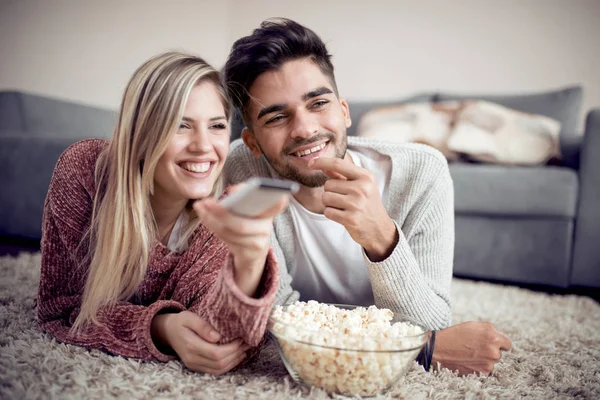 テレビを見て 自宅でポップコーンを食べて幸せなカップル — ストック写真