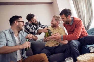 Dostluk, teknoloji, spor ve ev kavramı gülümseyen erkek arkadaşlar evde bira içmek.