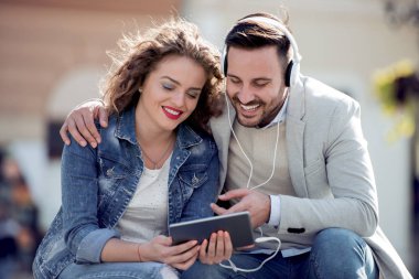 Şehrin bankta oturmuş ve müzik seven Çift.