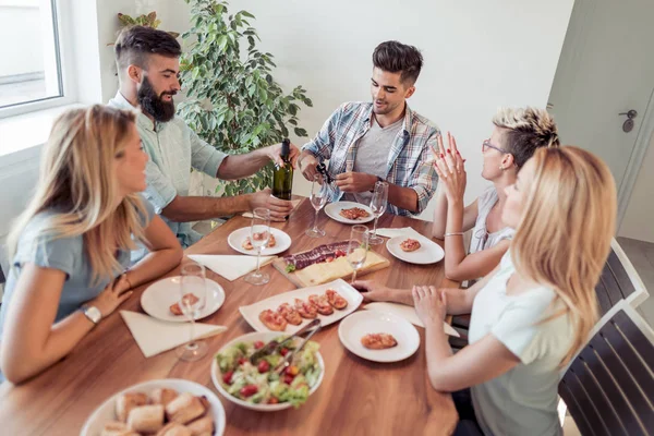 Group of happy people eating healthy meals at party dinner at home.