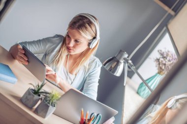 Ofisten dizüstü bilgisayarda çalışan genç kadın portresi.