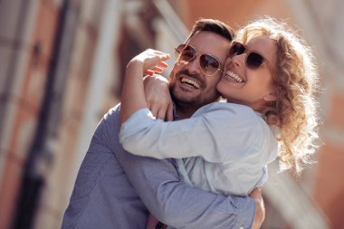 Açık havada eğleniyor ve gülümseyen mutlu genç bir çift. İnsanlar, sevgi, mutluluk ve yaşam tarzı kavramı.