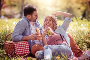 Mutlu çift birbirlerine gülümseyen güneşli bir günde bir piknik üzerinde. İnsanlar, sevgi, mutluluk ve doğa kavramı.