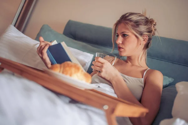 Ευτυχισμένη Γυναίκα Διαβάστε Βιβλίο Και Ποτό Χυμό Στο Κρεβάτι Πρωί — Φωτογραφία Αρχείου