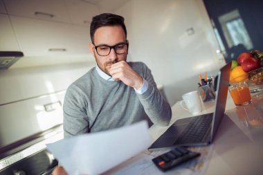 Genel müdürlükte dizüstü kullanarak yakışıklı genç işadamı portresi.