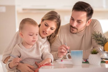 Gülümseyen aile birlikte evde çizim.