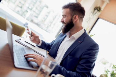 Ofis Masası, dizüstü bilgisayar üzerinde çalışan yakışıklı genç işadamı portresi.