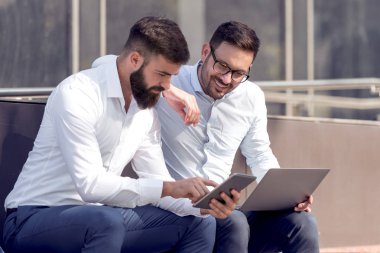 Park içinde laptop üzerinde çalışan iki emin iş adamları