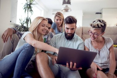 Birlikte kanepede oturan ve dizüstü film izlerken arkadaşlar.