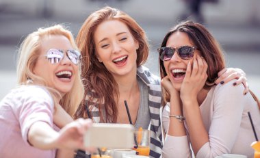 Grup arkadaşıyla birlikte bir kahve içer. Café, konuşuyor, gülüyor ve onların zaman zevk üç kadın.