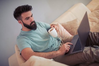 Genç çekici adam onun laptopunda evde tarama.