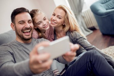 Mutlu aile alarak selfie evde oturma odasında kanepede.