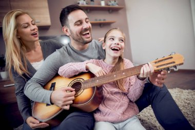 Babası kızı nasıl anne onlarla katta oturuyor iken akustik gitar öğretim.