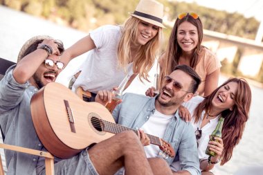 Kumsalda eğleniyor ve soğuk bir bira içme arkadaş.