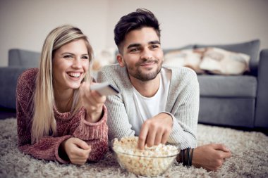 TV izlerken, evde patlamış mısır yemek mutlu çift.