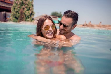 Seven havuzunda mutlu çift. Yaz tatili.