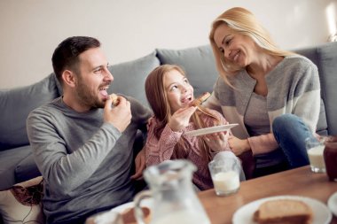 Üç sabahları kahvaltı onların oturma odasında birlikte olan aile.