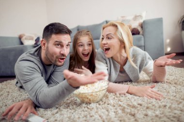 Baba, mather ve kız yerde, Tv izlerken ve patlamış mısır yemek