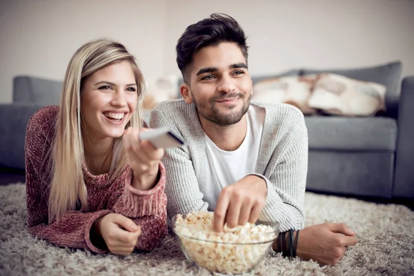 幸福的夫妇看电视和在家里吃爆米花 — 图库照片