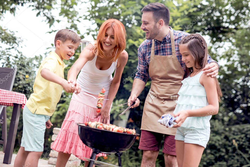 Dad teaches kids to make barbecue in backyard