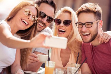 Arkadaşlar kafede harika bir zamandı. Gülümseyen ve bir kafede oturup, kahve içme ve birlikte zevk arkadaş.