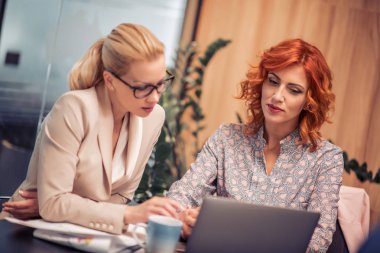 Söz ve birlikte modern ofisinde çalışan iki iş kadınları.