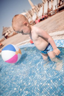 Çocuk gülümseyen bir yüzme havuzuna sahiptir.