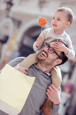Mutlu baba oğlu onun omuzlarında taşıyan alışveriş sonra eğlenceli yaşıyorsanız.