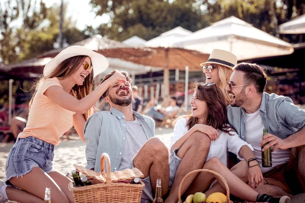  Gençler eğleniyor sağlıklı meyve ve içecekler ile sahilde piknik sırasında.