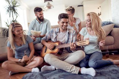 Eğleniyor ve gitar oturma odasında oynamaya arkadaş grubu 