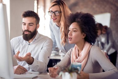 Ofiste bilgisayar üzerinde çalışan iş ortakları