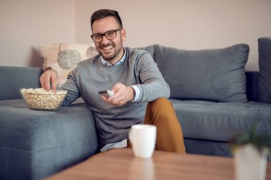 patlamış mısır yemek ve evde Tv izlerken genç adam