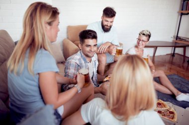 Bir grup genç insan birlikte eğlenirken pizza yemek