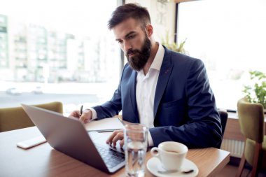 Ofis masası, dizüstü bilgisayar üzerinde çalışan genç işadamı portresi