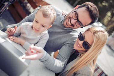 Aile birlikte vakit geçiriyor ve izlerken laptop açık havada üzerinde çizgi film