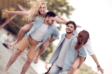 Mutlu genç arkadaşlar kumsalda eğleniyor