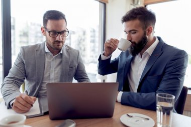 gülümseyen iş adamları iş ofiste dizüstü bilgisayarda kontrol