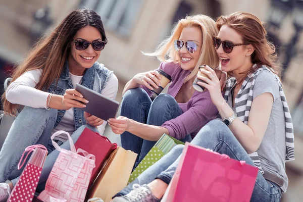 Drie Jonge Vrouwen Met Boodschappentassen Zoek Tablet Stad — Stockfoto