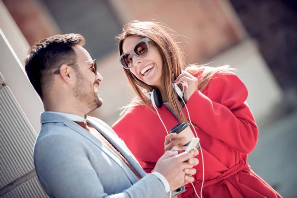 快乐的年轻夫妇在街上玩 而听音乐 — 图库照片