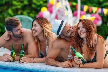 Bir grup mutlu arkadaş havuz partisi yapıyor. Arkadaşlık, tatil, eğlence ve mutluluk konsepti..