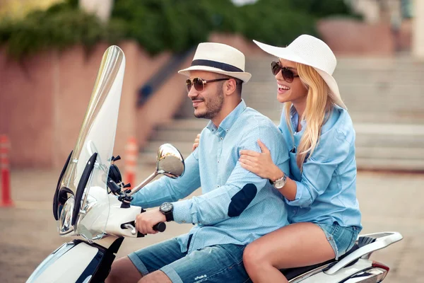 Cheerful couple in love on scooter driving together.