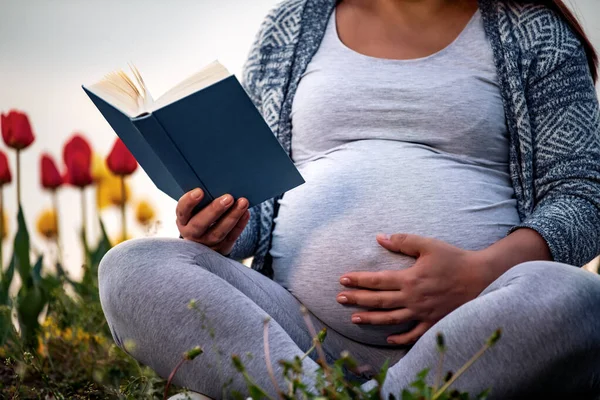 Mujer Embarazada Parque Leyendo Libro Flores Fondo —  Fotos de Stock
